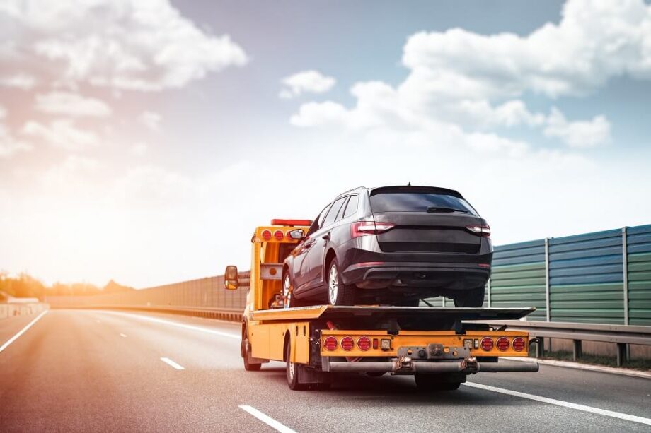 Na autostradzie porusza się autolaweta z samochodem osobowym na platformie.