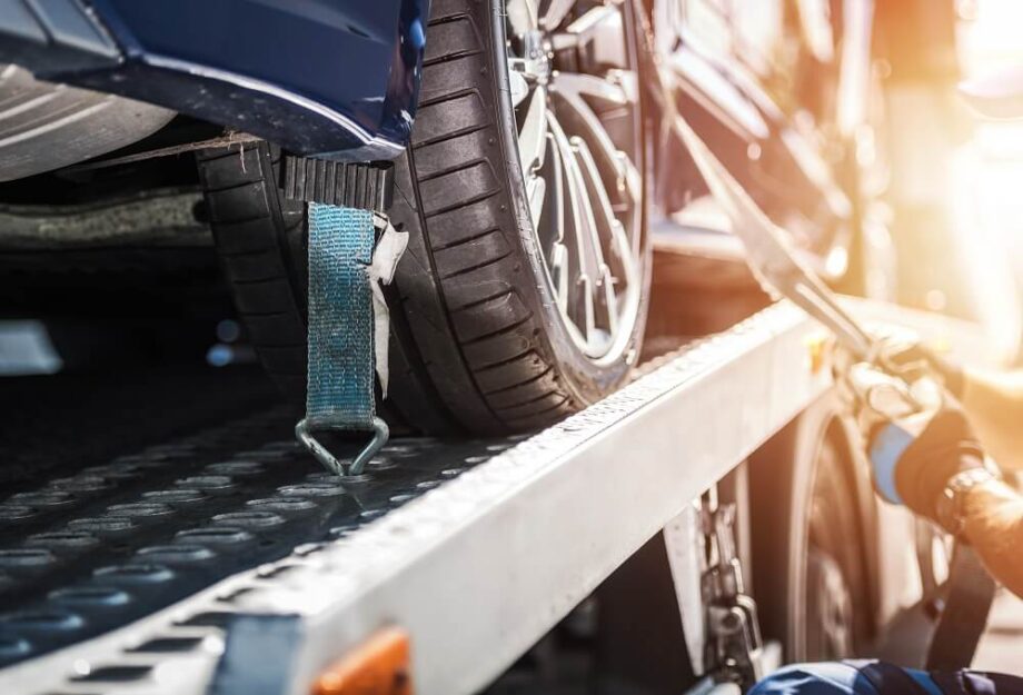 Na zdjęciu widać proces załadunku pojazdu na lawetę, co jest częścią transportu samochodów.
